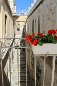 Sunlit Passages: Maze-like alleyways where intense sunlight reflects off classic Jerusalem limestone